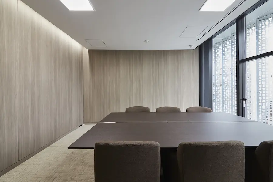 Minimalist conference room with a brown table and chairs.